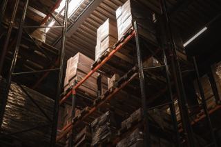 Un préparateur optimise la gestion des stocks en rangeant des cartons dans un entrepôt